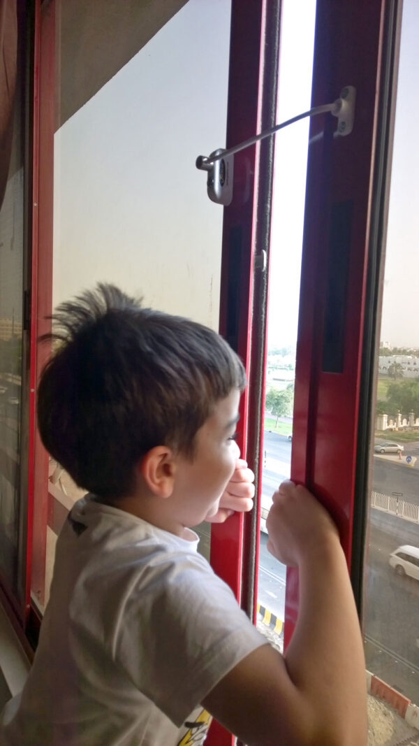 child-testing-his-new-Jackloc-window-safety-restrictor-on-dangerous-window